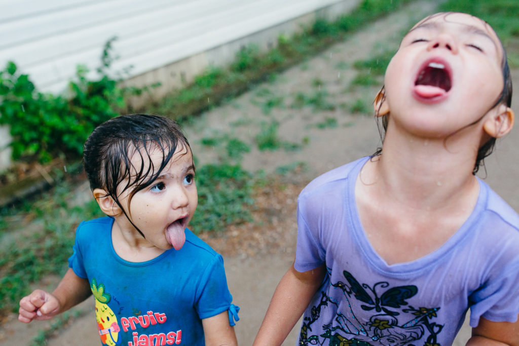 sisters playing in the rain