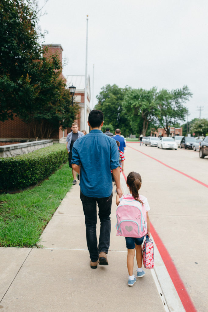 dad walking daughter to first day of school