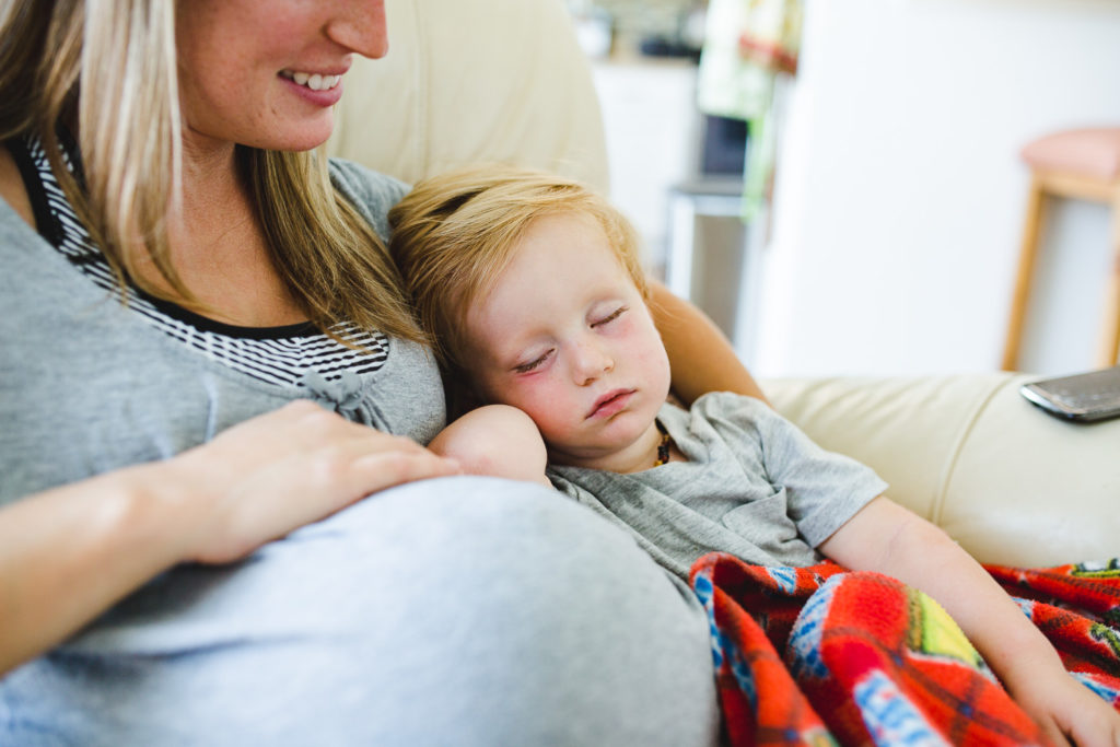 child sleeping on pregnant mother