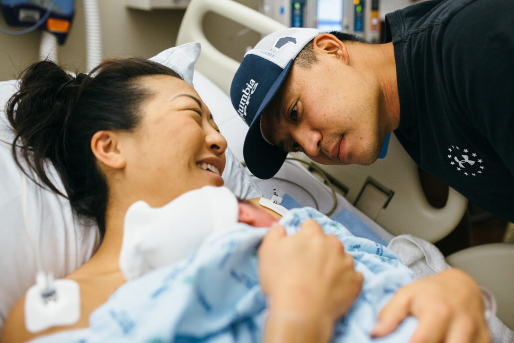 mother and father looking at newborn