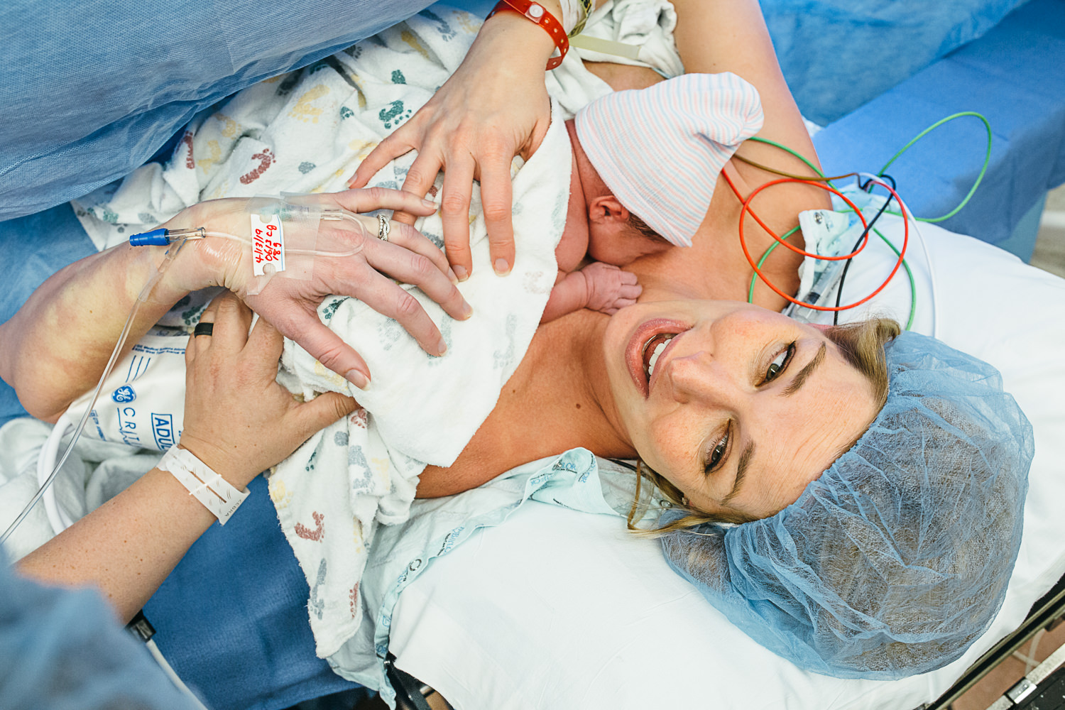 mother holding newborn baby while having a c-section