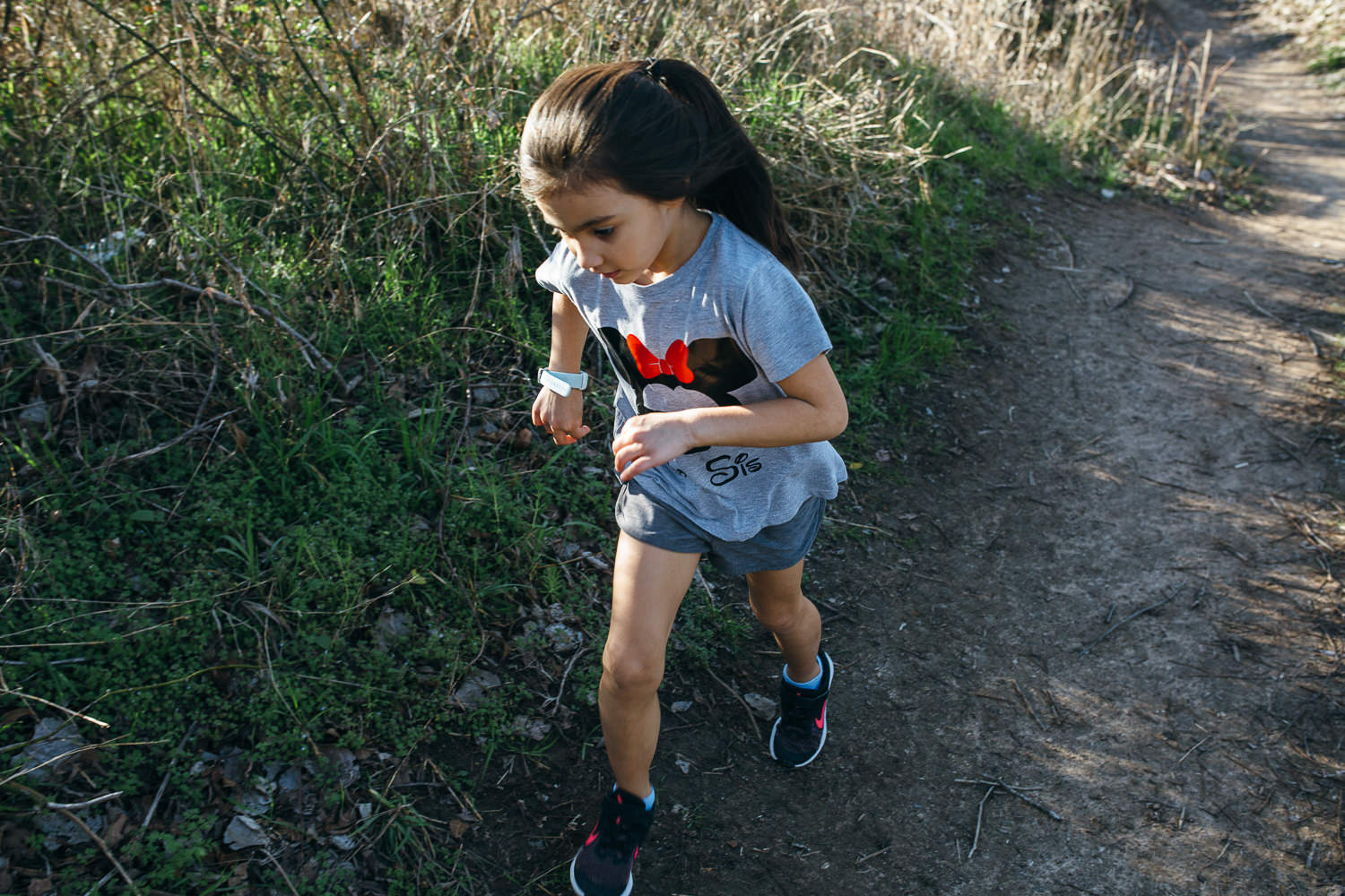 young-girl-wearing-a-minnie-mouse-shirt-running-on-a-trail