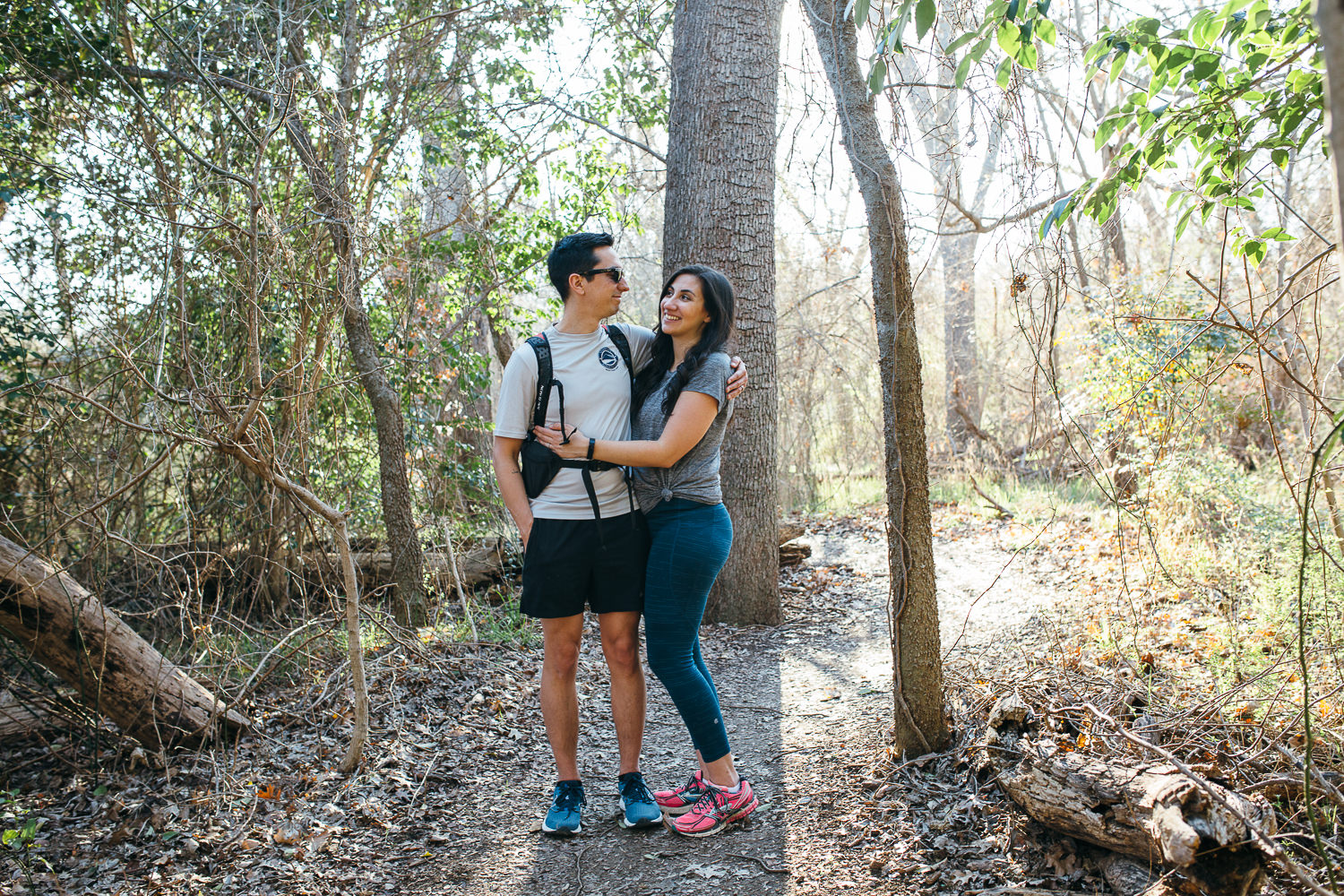 husband-and-wife-looking-at-each-other-and-hugging-on-a-hike