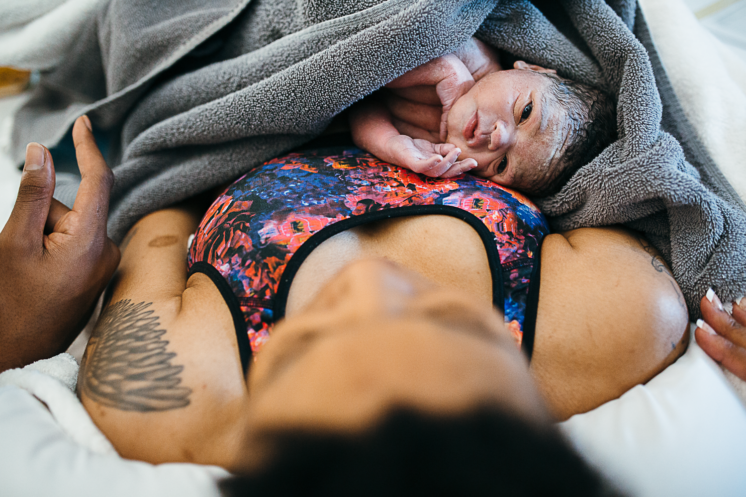 a black mother holds her newborn son just after birth
